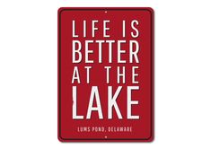 a red sign that says life is better at the lake with white lettering on it