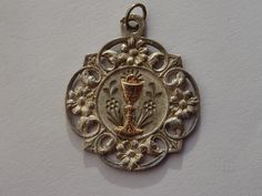 Religious antique silver ( MARKED ) French medal pendant charm medallion of Holy Chalice of the Holy Communion. Measures : 0,99 x 1,16 inches ( 2,52 x 2,95 cm ) The eye is on the place of the silver mark broken. Please look at all of the pictures, as they complete the description. I have a lot of these medals. I bought this medal on a brocante ( fleamarket in France). If you don't have paypal, you can pay by bank transfer. I deliver all over the world. Registered shipping is possible. If you wan Antique Pendant Charms For Gifts, Silver Round Pendant For Anniversary, Vintage Medallion Charms As Gifts, Vintage Medallion Charms As Gift, Antique Silver Necklace For Commemoration, Antique Engraved Charms For Gift, Silver Jewelry With Vintage Charm For Commemoration, Antique Engraved Charm For Gift, Antique Engraved Charms For Gifts