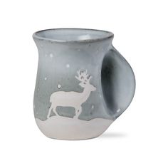 a white and gray cup with a deer on it's side in the snow