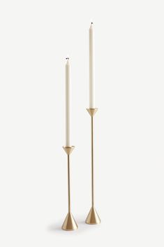 two white candles sitting next to each other