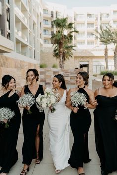 a group of women standing next to each other holding bouquets in their hands and smiling at the camera