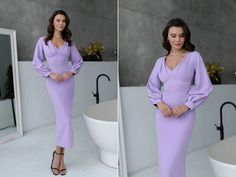 a woman in a purple dress standing next to a bathtub and sink with her hands on her hips