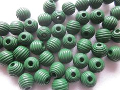 green beads are lined up on a white surface