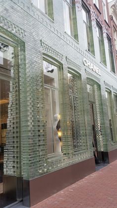 a store front that is made out of glass blocks and has a mannequin in the window