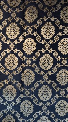 an intricately designed fabric with gold and white designs on blue background, close up