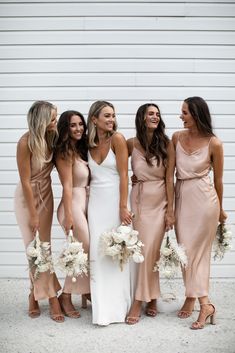 the bridesmaids are all dressed in different styles and colors, posing for a photo