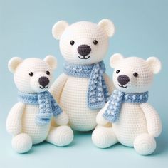 three crocheted white teddy bears wearing scarves and scarfs on blue background