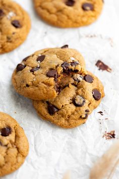 several chocolate chip cookies on top of white paper