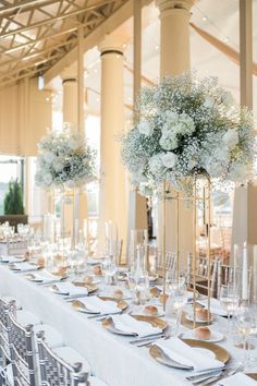 the tables are set with silverware and white flowers