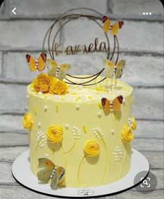 a yellow and white cake with butterflies on it