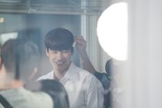 a young man is smiling while getting his hair done