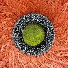 an orange flower with black and white speckles on it's center surrounded by netting