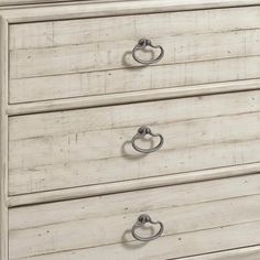 a white dresser with three drawers and two handles