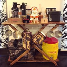 a table with luggage and coffee cups on it in front of a wall decorated with trees