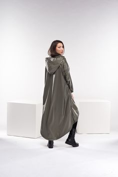 "This cyberpunk rain jacket has an asymmetrical design longer on the back and shorter on the front. It has a long double-side zipper along with two side pockets and a long belt to adjust the waistline to your personal needs and fashion style. The elastic finishes on the sleeve and the light fabric make this raincoat a \"must-have\" fashion piece for the season. ◼ FIT This cyberpunk jacket is of a loose fit. To have the same look as on our model, please check our body measurements size chart below and choose the correct size for you. ◾The model in the picture is wearing size XS in an Olive green color. ◼ FABRIC ◾polyester ◼ INFO: ◾ Worldwide express shipping - please provide a phone number for shipping documents ◼ CARE ◾ hand wash ◾ cold water 30 degrees ◾ do not iron ◼ CUSTOMIZATION ◾Don't Cyberpunk Rain, Cyberpunk Jacket, Goth Jacket, Steampunk Coat, Futuristic Clothing, Poncho Women, Plus Size Goth, Raincoat Outfit, Mode Mantel