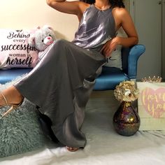 a woman is sitting on a blue chair with her legs crossed and wearing silver shoes