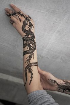 a woman's arm with a tattoo on it and a snake on the wrist