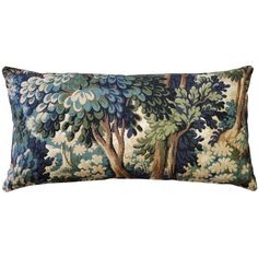 a blue and green pillow with an image of trees in the forest on it's side