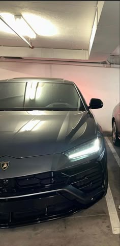 two cars parked in a parking garage with their lights on and no one is inside