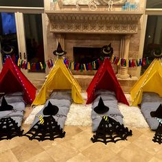 four teepee tents sitting in front of a fire place