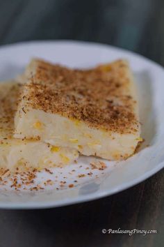 two pieces of cake on a white plate with cinnamon sprinkles and powdered sugar