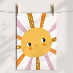 a poster hanging on a clothes line with the sun in the middle and lines across it