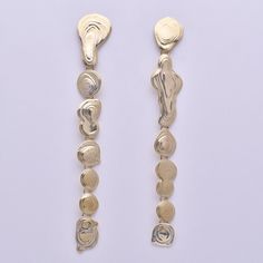 Lange Tropfohrringe aus Messing mit Stiften und Verstärkungen aus Sterlingsilber. Wie eine Kette aus goldenen Wassertropfen. 
Handgefertigt in unserem Studio in Los Angeles.
Details:
-Linker Ohrring ist 5 1/8" hoch.
-Rechter Ohrring ist 4 7/8" hoch.
-Tropfen baumeln an Messingösen für Bewegung.
-Messing mit Sterlingsilberpfosten und Butterfly-Rückseiten. Modern Gold Long Drop Earrings, Long Drop Brass Linear Earrings For Party, Gold Drop Linear Earrings For Party, Metal Long Drop Linear Earrings, Contemporary Gold Long-drop Earrings, Gold Metal Drop Linear Earrings, Gold-tone Long Drop Linear Earrings, Gold Dangle Drop Earrings For Party, Gold Linear Drop Earrings