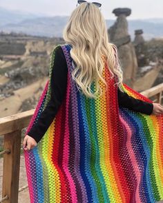 a woman with blonde hair wearing a multicolored crocheted shawl