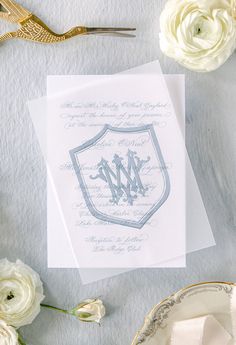 the wedding stationery is laid out next to flowers and napkins on a table