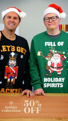 two men wearing ugly christmas sweaters and santa hats