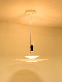 a modern light fixture hanging from the ceiling in a room with white walls and flooring