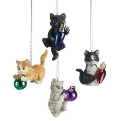 four ornaments in the shape of cats hanging from chains with bells on each ornament