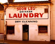 an old laundry store is painted white and has red lettering on the front window that says, soon lee chinese laundry dry cleaning