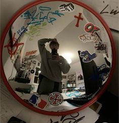 a man taking a selfie in front of a mirror with stickers all over it