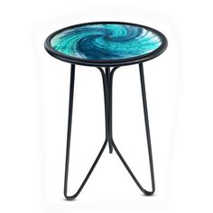 a blue and black table with an artistic design on the top, sitting in front of a white background