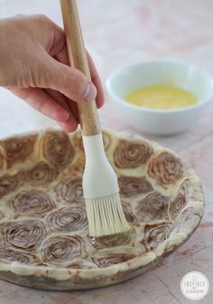 a person is holding a brush over a dish