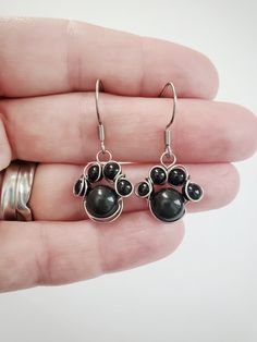 "These adorable little paw prints are made with 4mm and 8mm gemstone beads. They are perfect for animal lovers! Made with 100% stainless steel 24 gauge wire and earring hooks. They hang approximately 0.75\" down from earring hook.  The earrings will come on an earring card with silicone earring backs, and packaged in a charming box, perfect for easy gifting! Amethyst is a transparent to translucent stone that has a lavender to reddish violet hue.  It is found in many locations around the world, Wire Wrapped Paw Print, Kitten Earrings, Wire Creations, Paw Print Earrings, Lover Jewelry, Dog Earrings, Earring Card, Plastic Earrings, Earrings Wire