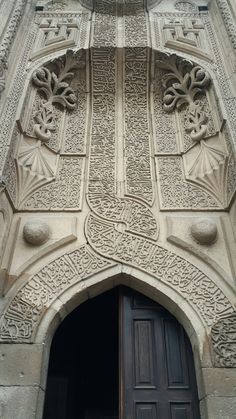 an ornate door and window on the side of a building with carved stone work above it