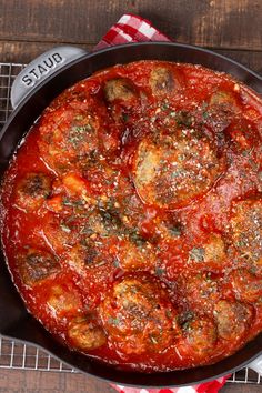 a deep dish pizza with meatballs and tomato sauce in a cast iron skillet