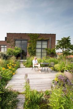 a man sitting on a bench in the middle of a garden