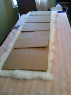 cardboard boxes are laid out on a table with fluffy white fur around them and one box is open