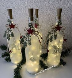 three bottles with christmas lights in them