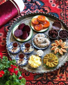 a tray filled with different types of food on top of a table next to flowers