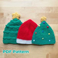 three crocheted christmas hats sitting on top of a wooden floor