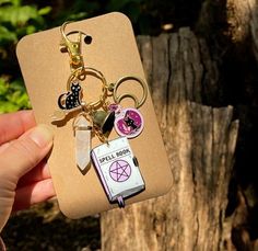 a person holding up a cell phone case with keychains and charms on it