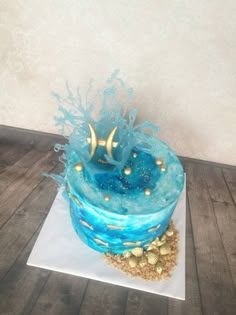 there is a blue cake with gold decorations on it