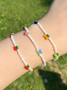 a woman's arm with three bracelets made out of glass beads and multicolored beads