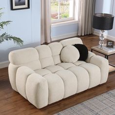 a white couch sitting on top of a hard wood floor