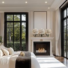 a bedroom with a fireplace and large windows