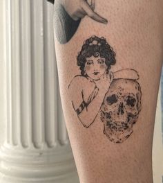 a woman's leg with a skull and hand drawn on the side of it